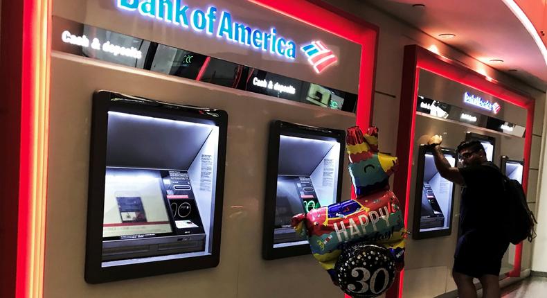 FILE PHOTO: A man uses an ATM machine next an inflatable plastic balloon inside a Bank of America branch in Times Square in New York, U.S., August 10, 2019. REUTERS/Nacho Doce/File Photo