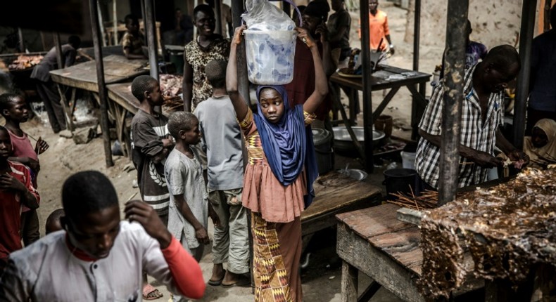 A girl selling water waits for costumers at a market, which was attacked last year by Boko Haram Islamists, in the Nigerian city of Mubi