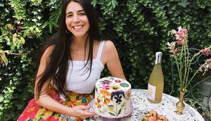 Loria Stern, the owner of Eat Your Flowers, next to her bakery's signature edible flower-pressed cake.Courtesy of Loria Stern