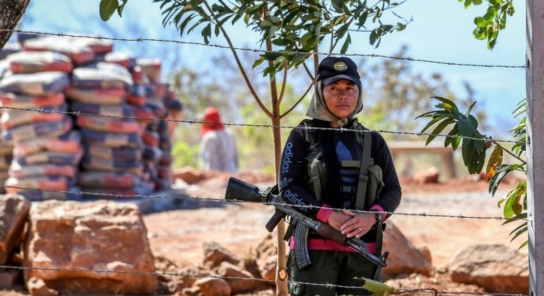 A member of the FARC leftist guerrilla stands guard at the entrance to the area where the rebels are gathering in the municipality of San Jose de Oriente, Cesar department, northern Colombia on February 28, 2017