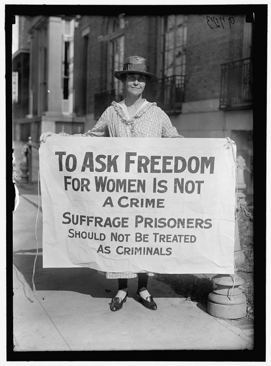 Kobieta trzymająca plakat protestujący przeciwko uwięzieniu sufrażystek w 1912 r.