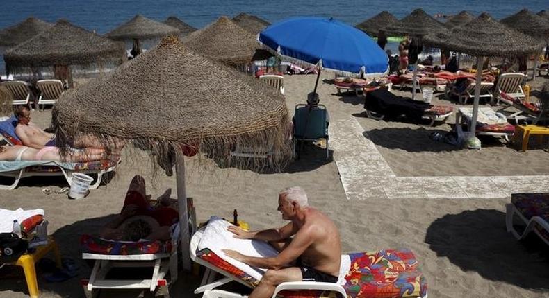 Tourists sunbathe on a beach in Fuengirola, on Costa del Sol, southern Spain, July 12, 2015. 