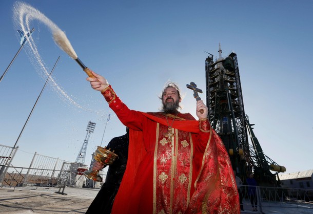 An Orthodox priest conducts a blessing in front of the Soyuz MS-04 spacecraft set on the launchpad a