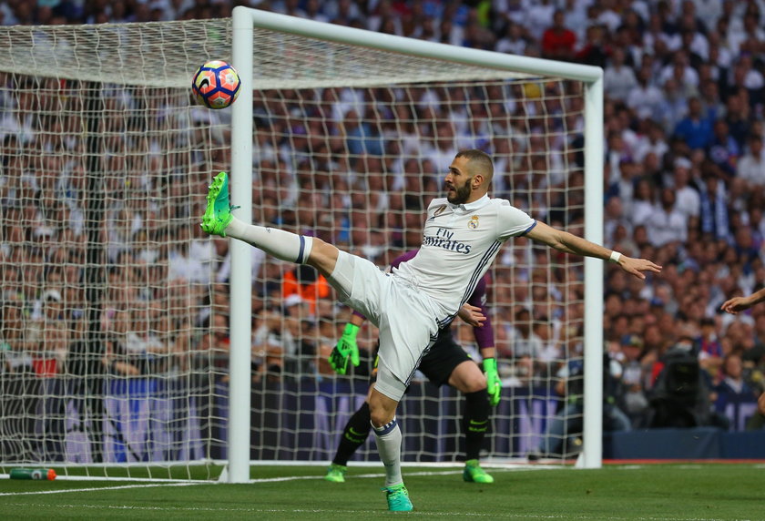 Real Madrid's Karim Benzema in action with Barcelona's Gerard Pique and Sergi Roberto