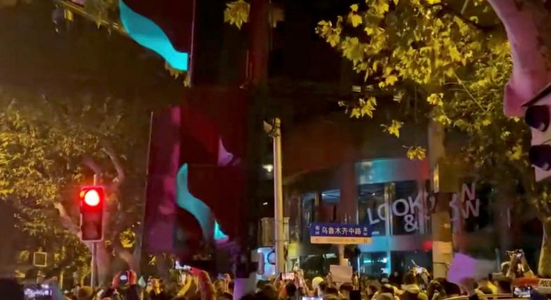 People protest against coronavirus disease (COVID-19) curbs, at the site of a candlelight vigil for victims of the Urumqi fire, in Shanghai, China, in this screengrab from a video released on November 27, 2022.Reuters