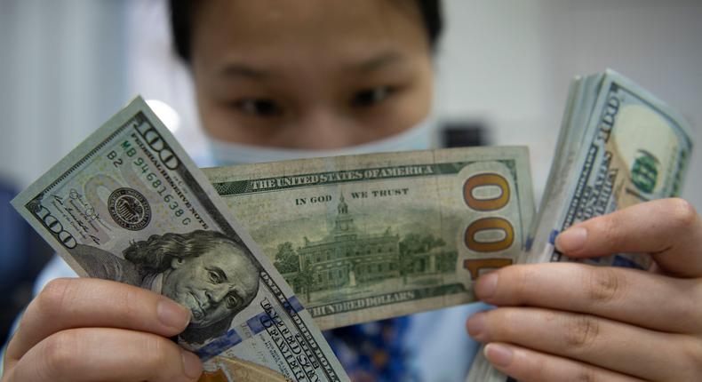 A staff member counts US dollar notes at a bank in Jiangsu Province, China.