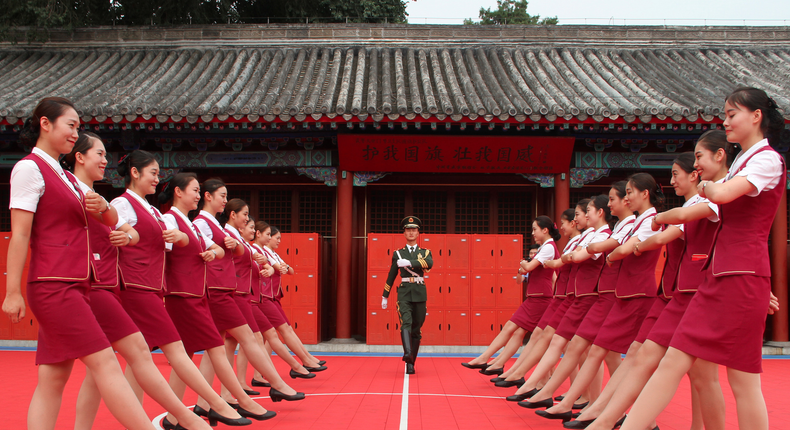 Train attendants visiting the national flag guard during a patriotic education event ahead of the 90th anniversary of the founding of the Chinese People's Liberation Army in Beijing.