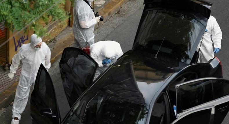 Greek forensic experts inspect Lucas Papademos' car in Athens, on May 25, 2017