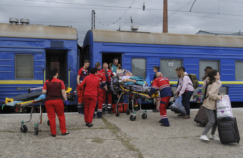 Ukraińscy pracownicy służby zdrowia wyładowują ranną osobę ze specjalnego pociągu na stacji kolejowej we Lwowie, Ukraina, 21 maja 2022 r. Pociąg przetransportował ukraińskich żołnierzy i cywilów rannych w toczących się bitwach między wojskami ukraińskimi i rosyjskimi po rosyjskiej inwazji na Ukrainę