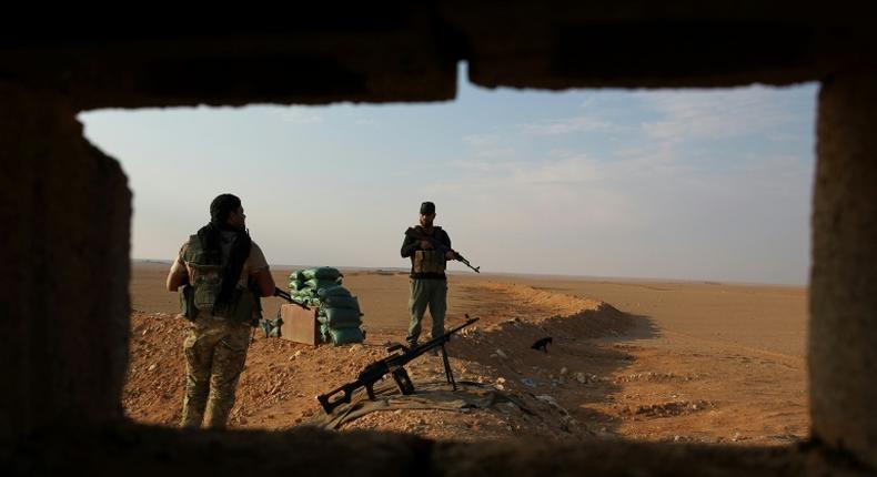 Iraqi Shiite fighters of the Hashed al-Shaabi paramilitary force secure the border area with Syria in al-Qaim in Iraq's Anbar province late last year