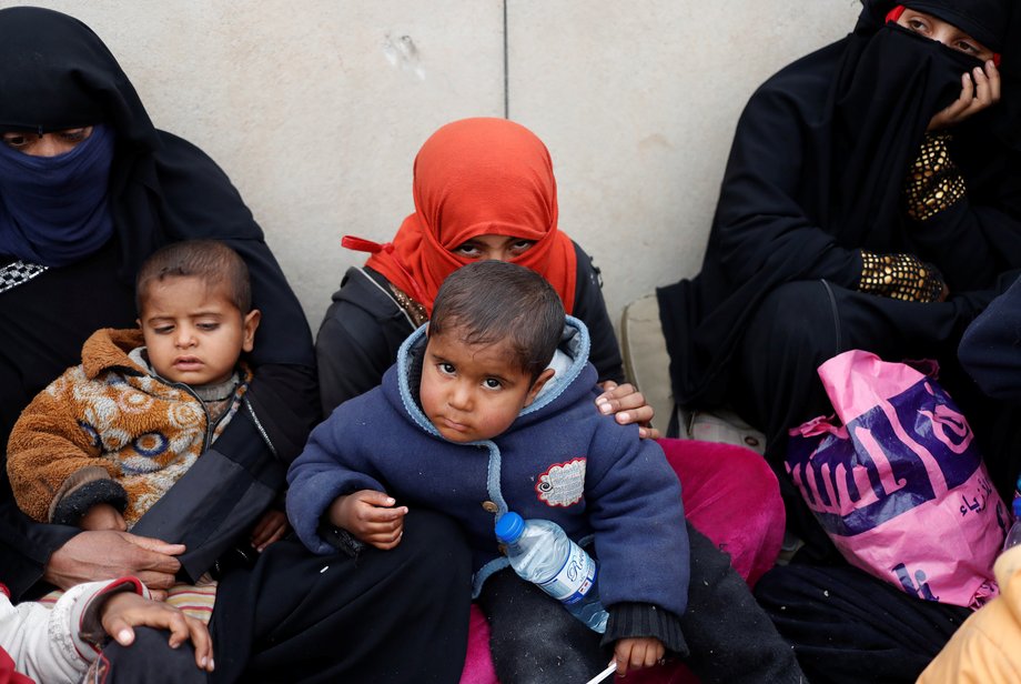 Iraqi women and children sit after they crossed from an ISIS-controlled part of Mosul to an Iraqi-controlled part of Mosul, Iraq, March 1, 2017.