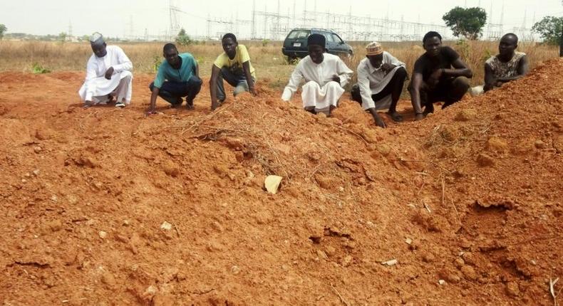 Members of the Islamic Movement of Nigeria (IMN), a Shiite group, pray at a mass grave in the outskirts of northern Nigerian city of Kaduna