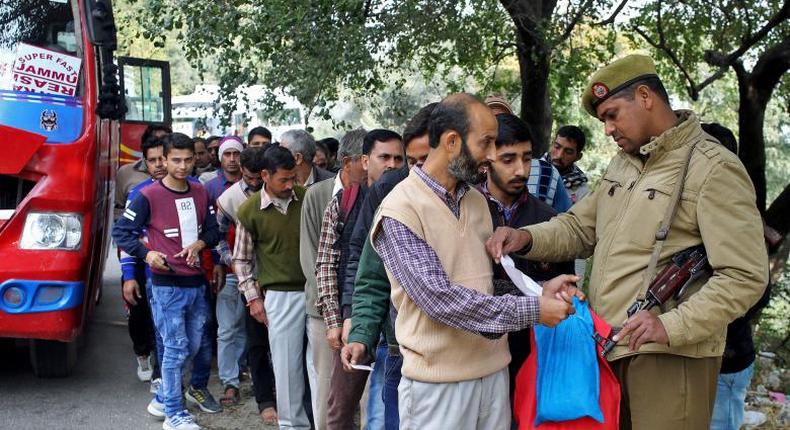 A policeman checks an identity card of a passenger at a checkpoint amid tightened security.