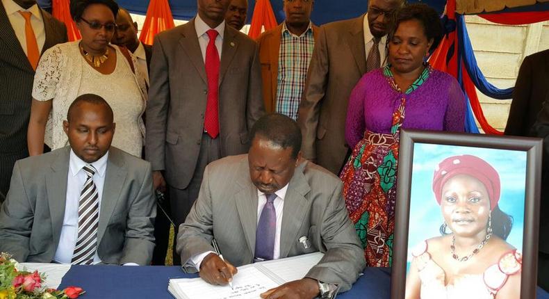 File image of Raila Odinga signing a condolence book for Monica Amollo. He is among national leaders who has mourned Achieng Oneko's widow Loyce Anyango