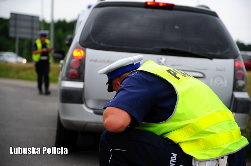 Policjant sprawdza stan techniczny auta