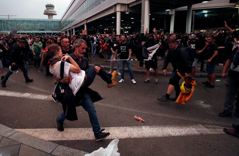 Passengers look as a police officer walks past at Barcelona's airport, during a protest after a verd