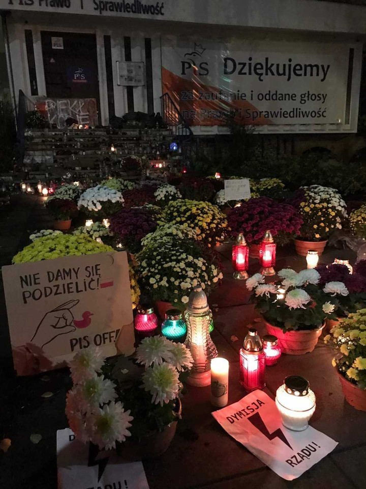 Chryzantemy i znicze przed siedzibą PiS w Szczecinie