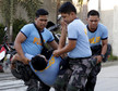 Police carry a colleague who collapsed while retrieving bodies of workers killed during a fire at a slipper factory in Valenzuela