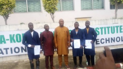 Rector of Korea-Nigeria Friendship Institute (NKFI) of Vocational and Advanced Technology, Lokoja, Mr Williams Charles (middle), Principal of St. Peter’s College, Idah, Mr Zakari Jonah, (second left) in a group photograph with the students who were awarded scholarship by the institute for built SUV, on Wednesday.