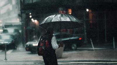 A man under an umbrella in rainy weather [Image Credit: Lerone Pieters]