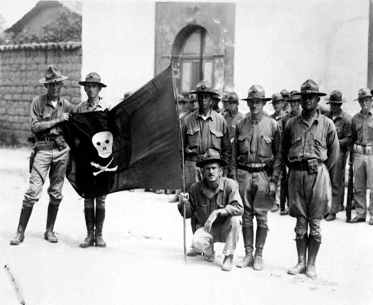 United States occupation of Nicaragua as part of the Banana Wars. United States Marines pose with the captured flag of Augusto C. Sandino in 1932.