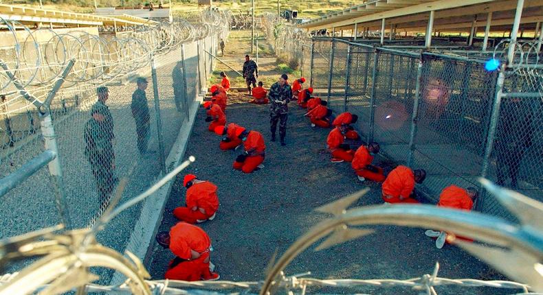 A file photo shows detainees sitting in a holding area watched by military police at Camp X-Ray inside Naval Base Guantanamo Bay, Cuba.
