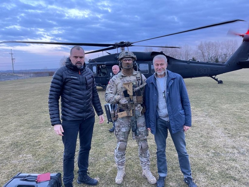 Roman Abramowicz (pierwszy z prawej) ochraniany przez żołnierza GROM i ówczesny minister w kancelarii prezydenta - Jakub Kumoch (po lewej). W tle Black Hawk polskich sił specjalnych (archiwum autora)