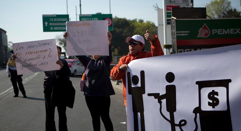 A protester gives a thumbs up to honking drivers as he and others angry over gas price hikes block a gas station on Calzada de Tlalpan in Mexico City, January 3, 2017.