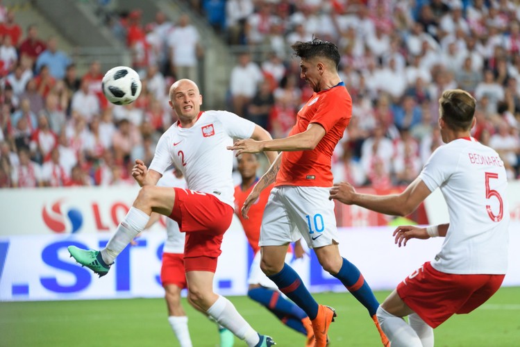 Chilijczyk Diego Valdes (C) strzela bramkę, obok Polacy - Michał Pazdan (L) i Jan Bednarek (P)