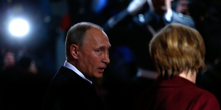 Russian President Vladimir Putin talks to German Chancellor Angela Merkel.