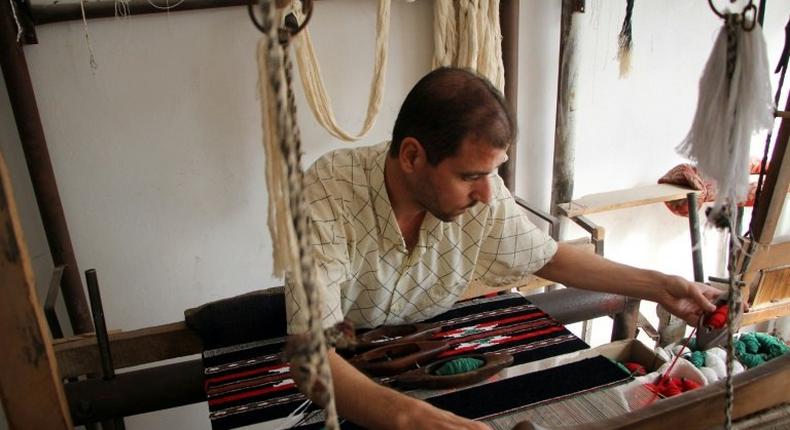 Syrian weaver Abu Ahmed works his loom on the last day before the workshop is forced to close due to a lack of thread imported from conflict-ridden Aleppo