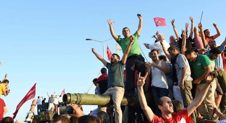 Turkish pro-regime activists celebrate after seizing a tank in Istanbul, during the failed July 15 coup in which 300 people were killed