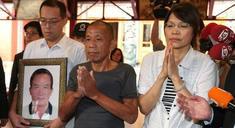 Shen Jui-chang (C), who was the chief engineer on a fishing boat that was seized south of the Seychelles in March 2012, prays at Hsing Tian Kong temple in Taipei City on October 26, 2016