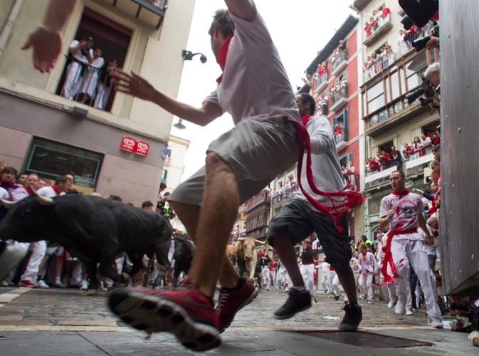 Uczestnicy fiesty na ulicach Pampeluny. Gonitwa trwa