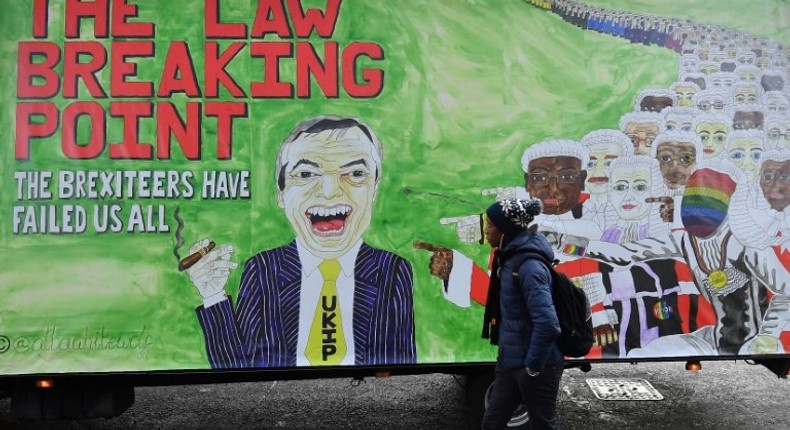 A man walks past a billboard in London depicting former UK Independence party leader Nigel Farage