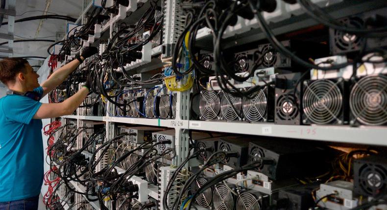 An employee inspects machines for the production of bitcoins and lightcoins at the Kriptounivers (CryptoUniverse) mining centre.
