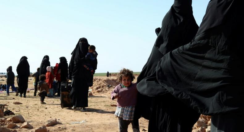 Civilians fleeing from fighting between Syrian Democratic Forces (SDF) and Islamic State (IS) jihadists in the frontline village of Baghuz, await to be screened and registered by the SDF in eastern Deir Ezzor province on January 31, 2019