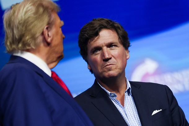 Tucker Carlson patrzy na Donalda Trumpa podczas wiecu sponsorowanego przez konserwatywną grupę Turning Point USA w Duluth w stanie Georgia, 23 października 2024 r.