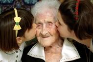 The World's oldest woman, Jeanne Calment, 120 years old, is kissed by two young girls during a speci