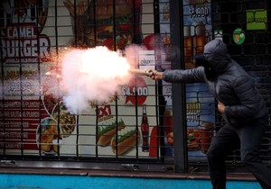 Demonstrant ispaljuje baklju tokom sukoba na protestu u Santjagu | Foto: Reuters