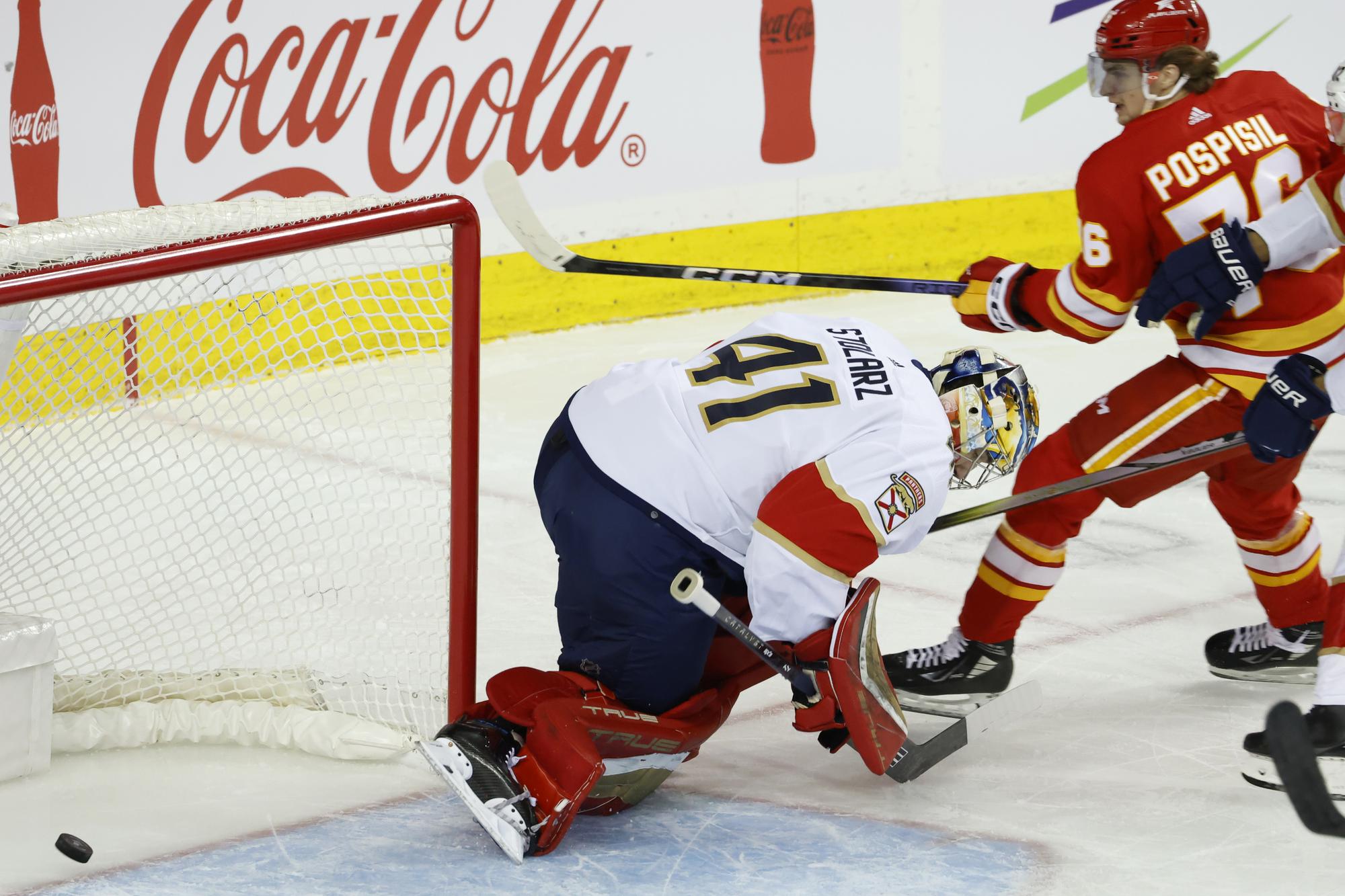 Slovenský hokejista v drese Calgary Flames Martin Pospíšil strieľa gól za chrbát brankára Floridy Panthers Anthonyho Stolarza.