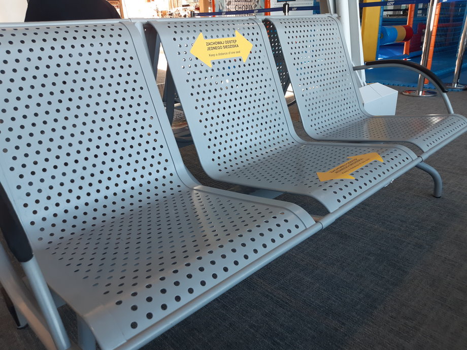 Na Lotnisku Chopina w Warszawie o zachowaniu dystansu przypominają naklejki na krzesłach. 