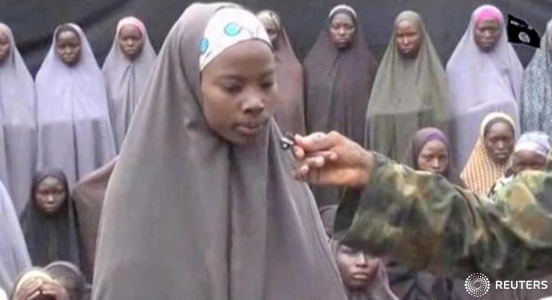 A still image from a video posted by Nigerian Islamist militant group Boko Haram on social media and seen by Reuters on August 14, 2016, shows a girl who identified herself to a masked man as Maina Yakubu and that she is from Chibok, as dozens of other girls the group said are school girls kidnapped in the town of Chibok in 2014, are seen in the background.  Social Media    ATTENTION EDITORS - THIS IMAGE WAS PROVIDED BY A THIRD PARTY. EDITORIAL USE ONLY. NO RESALES. NO ARCHIVE. REUTERS IS UNABLE TO INDEPENDENTLY VERIFY THIS IMAGE.   - RTX2KPJ0