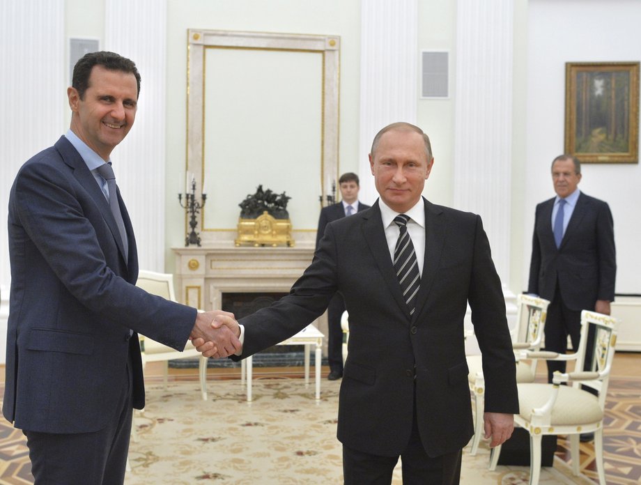 Russian President Vladimir Putin, right, shakes hands with Syrian President Bashar Assad.