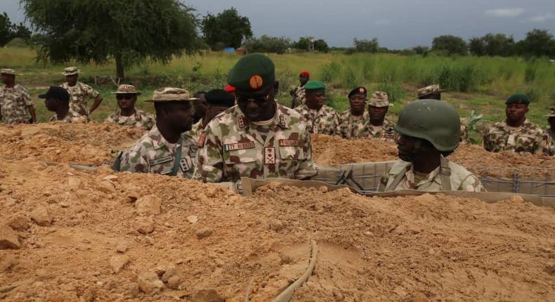 Chief of Army Staff, Lt.-Gen. Tukur Buratai (L), giving instructions to one of the soldiers in trench in frontline in Borno North