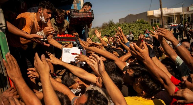 Migrants desperate to get some of the food being distributed to them two days after Greece's biggest and most notorious migrant camp, Moria, was destroyed by fire