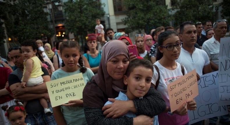 A Muslim woman hugs a child during a demonstration in Granada on August 23, 2017 in protest against a surge in anti-Islamic hate crimes following the deadly attacks in Barcelona and Cambrils