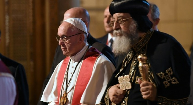 Pope Francis (L) walks alongside Coptic Pope Tawadros II (R) during a visit to Cairo on April 28, 2017