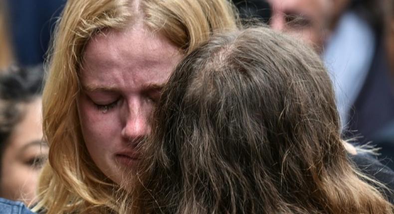 Friends of Frenchwoman Julie Huynh mourn at the country's embassy in Bogota during a homage to her and two other women killed in a bombing at a mall