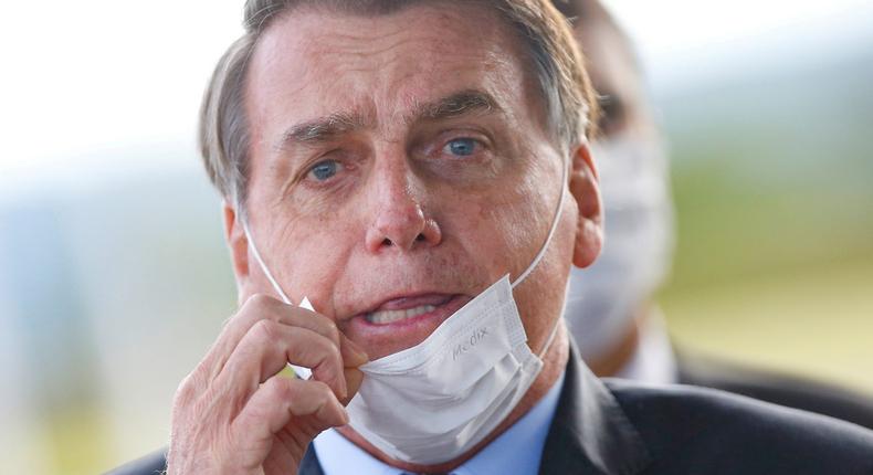 FILE PHOTO: Brazil's President Jair Bolsonaro adjusts his mask as he leaves Alvorada Palace, amid the coronavirus disease (COVID-19) outbreak in Brasilia, Brazil May 13, 2020. REUTERS/Adriano Machado TPX IMAGES OF THE DAY/File Photo